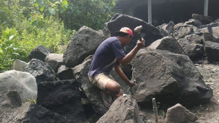 memecahkan batu menggunakan palu dan pahat